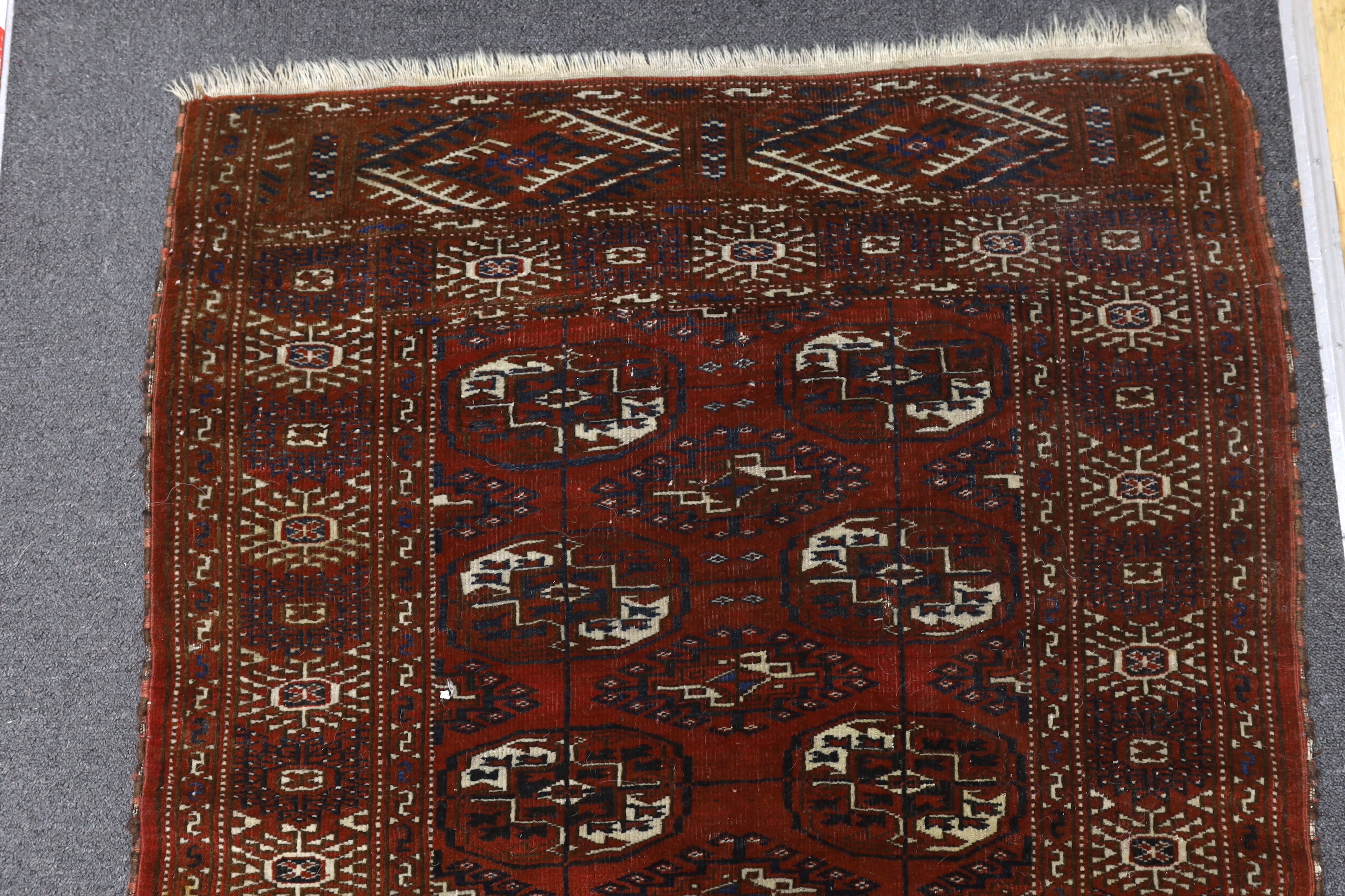 A Turkeman burgundy ground rug, 126 x 94cm